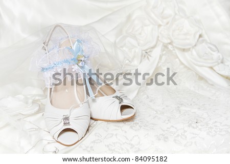 stock photo Bride's shoes garter with blue ribbon wedding dress