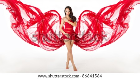 Woman in red dress flying dress as wings, waving  on a wind flow. White background