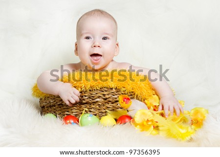 Happy baby in Easter basket with eggs. Easter holiday concept: nest with baby chick