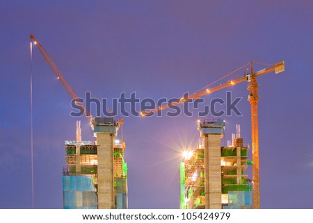 Big Construction Site with Working Cranes at dusk for Business Background
