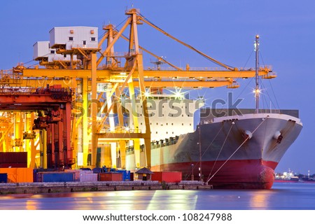 Industrial Container Cargo freight ship with working crane bridge in shipyard at dusk for Logistic Import Export background Industrial Container Cargo freight ship with working crane bridge in shipyard at dusk for Logistic Import Export background