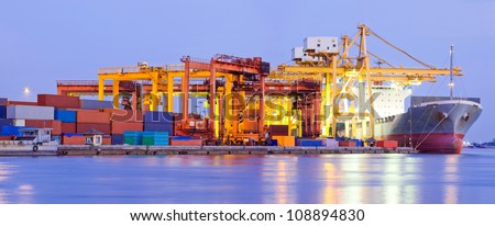 Panorama of Industrial Container Cargo freight ship with working crane bridge in shipyard at dusk for Logistic Import Export background