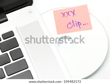White laptop with Sexy Clip dvd disk in slot-loading drive on a white background.