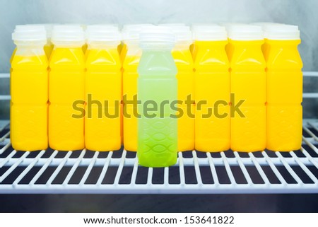 Guava juice against Orange juice bottles in refrigerator, leadership concept