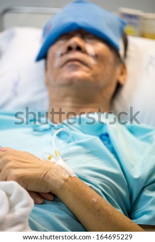 mature senior man Patient sleeping in hospital bed (Selective focus at hand)