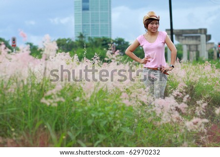 a south east asian girl in pink blouse with hat in flower and grass garden