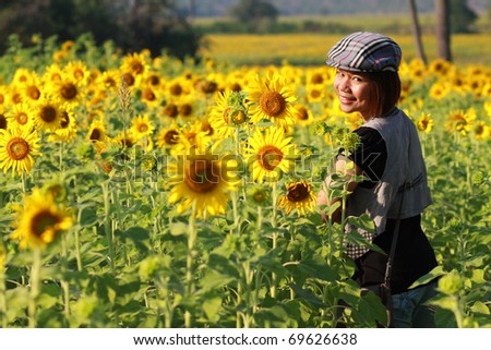Asia short hair girl with cap in beautiful sunflower farm