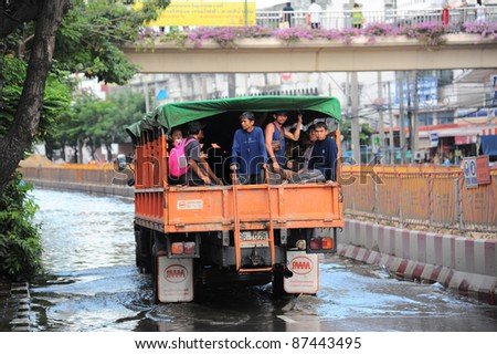 BANGKOK - OCTOBER 26: Unidentified people sit and stand in big truck to escape rising flood waters at Charansanitworn Road, Bang Plud, in Bangkok, Thailand on Oct. 26, 2011.