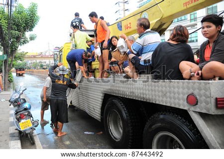 BANGKOK - OCTOBER 26: Unidentified people sit and stand in big truck to escape rising flood waters at Charansanitworn Road, Bang Plud, in Bangkok, Thailand on Oct. 26, 2011.