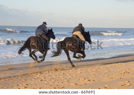 Two men horse racing on the beach