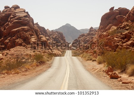A highway rolling through red rock canyons in Nevada