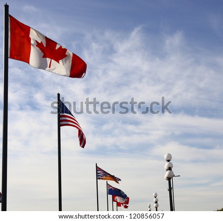 A row of international flags, including Canada and United States on nice sky