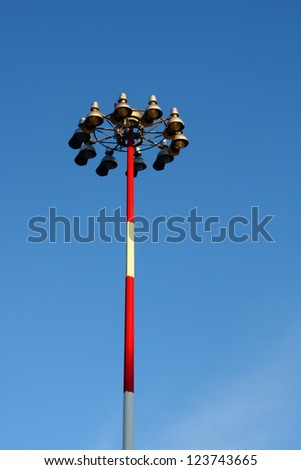 A classic old light pole with red and white stripes under Blue skies