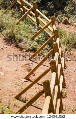 A split rail fence curving across the desert