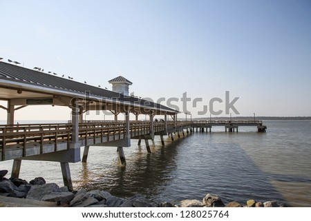 An old wooden and concrete pier jutting out into a calm bay