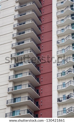 A column of balcones on a high rise condominium tower with a red stucco wall