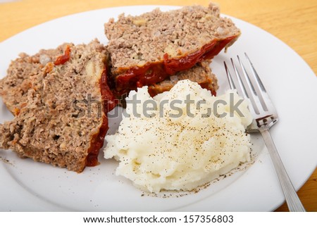 A hearty dinner of meat loaf and mashed potatoes on a white plate