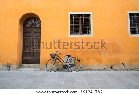 A bicycle leaning against an old plaster wall in Tuscany