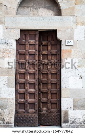 An old wood door in a stone building with iron studs