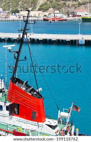 Bright red conning tower on a tug boat in a harbor on blue seas