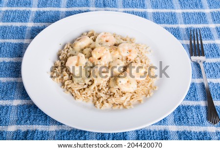 Shrimp scampi with garlic butter on a plate of brown rice