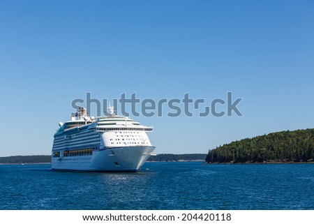 Huge, white, luxury cruise ship anchored in blue water
