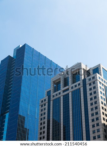 Two skyscrapers in Chicago, one old classic stone and the other modern glass