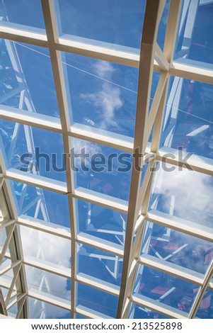 White steel and glass atrium ceilings under blue skies