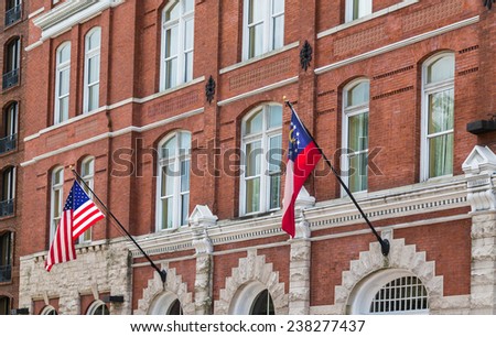 An old brick building in Savannah with American and Georgian flags