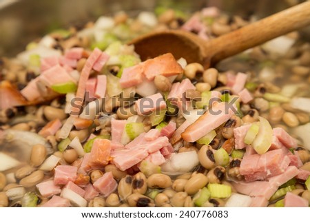 Cooking a pot of black-eyed peas with ham, onion and celery