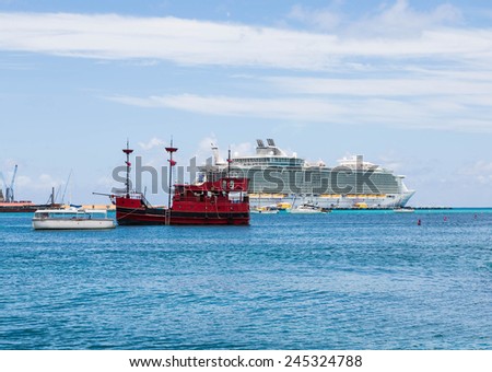 A red pirate ship in harbor of Philipsburg, St Marting with cruise ship in background