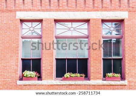 Flowers in Window boxes of three windows in an old brick building