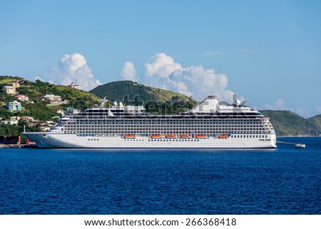 Luxury cruise ship anchored across a deep blue bay