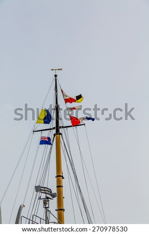 British and Naval flags on an old wood ship\'s mast