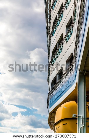Decks up side of cruise ship over yellow life raft