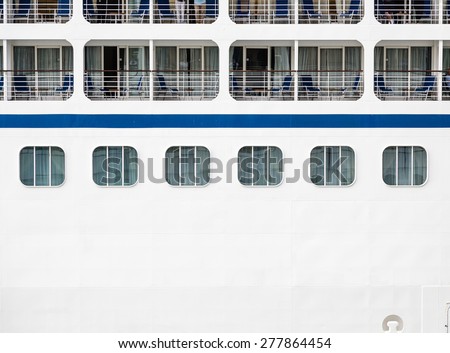 Windows, verandas and decks on the side of a massive luxury cruise ship