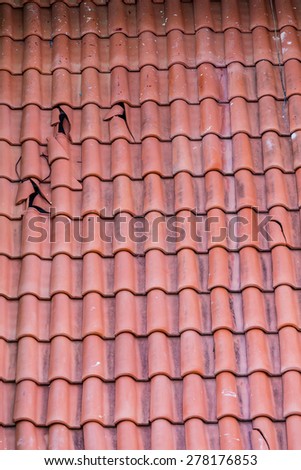 Broken clay tiles on a red roof