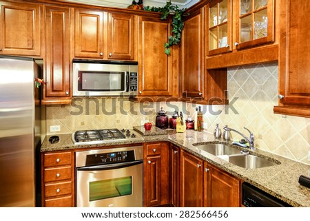 Dark wood cabinets with granite countertops and stainless steel appliances