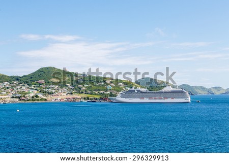 Luxury cruise ship anchored across a deep blue bay on St Kitts