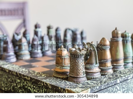 A nice, custom chess set on a table in window light