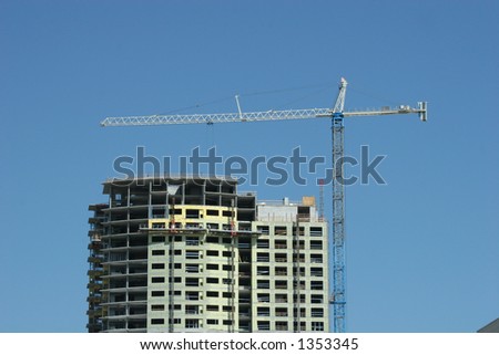 Crane atop steel and concrete construction tower