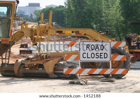 Road closed sign and paving equipment
