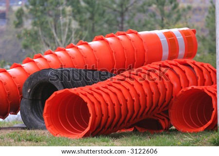 Stacks of orange and white traffic barrels at construction site