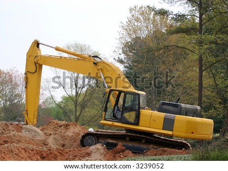 A front end loader atop a pile of dirt