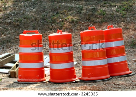 Orange and white traffic barrels at a road work site