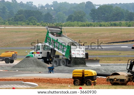 Dump truck dumping gravel on an airport construction site