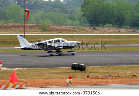 A small plane touching down on two wheels