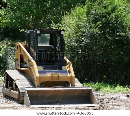 A small front end loader working a load of gravel