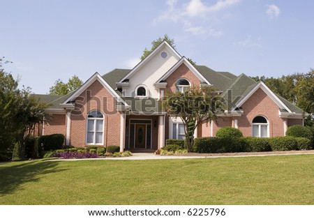 A nice brick house with a lawn and sidewalk