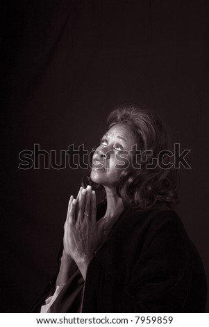 A spiritual  woman looking to heaven and praying in black and white